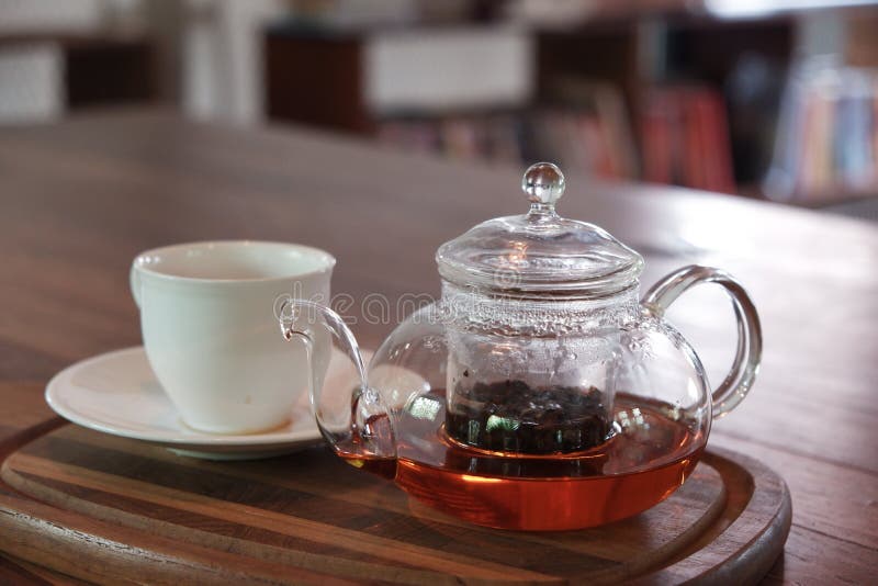 Tee Earl Grey im Glasteetopf auf h?lzerner Platte mit wei?er Schale stockbild Tee Earl Grey im Glasteetopf auf h?lzerner Platte mit wei?er Schale stockbild
