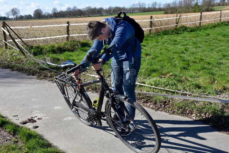 Teeange boy checks his bicycle