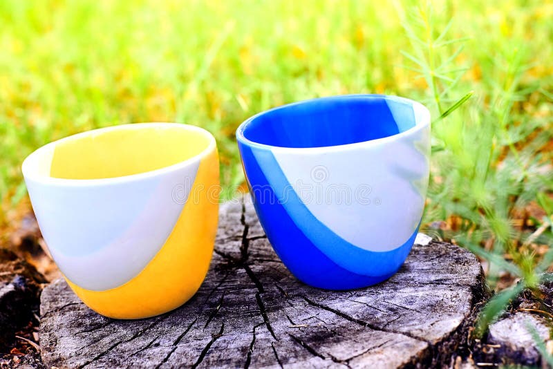 a small bowl shaped container for drinking from, typically having a handle. a small bowl shaped container for drinking from, typically having a handle.