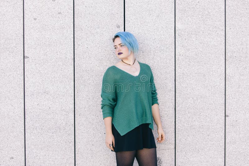 Teen androgynous sad woman with blue dyed hair isolated on the s