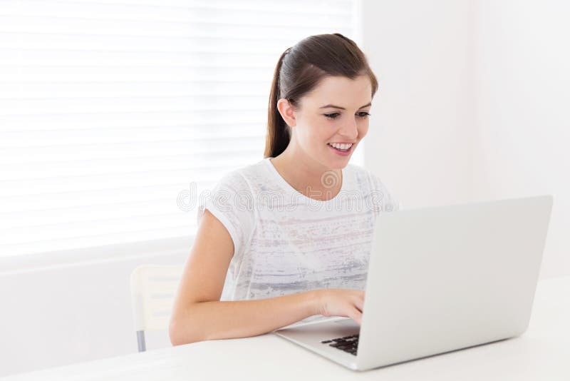 Pretty teen girl using laptop at home. Pretty teen girl using laptop at home