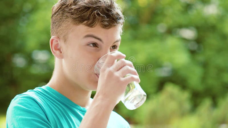 Teen boy drinks water from a bottle, Stock Video