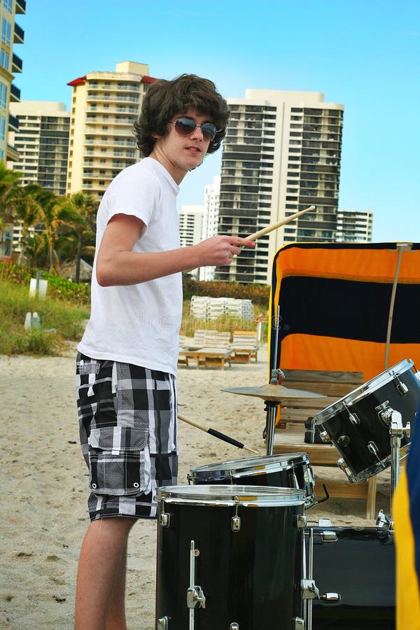 Teen boy with drums on the beach royalty free stock photography Teen boy with drums on the beach royalty free stock photography