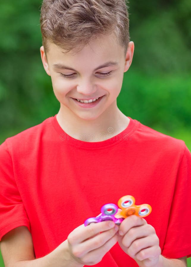 Teen Boy with Spinner Toy in Park Stock Image