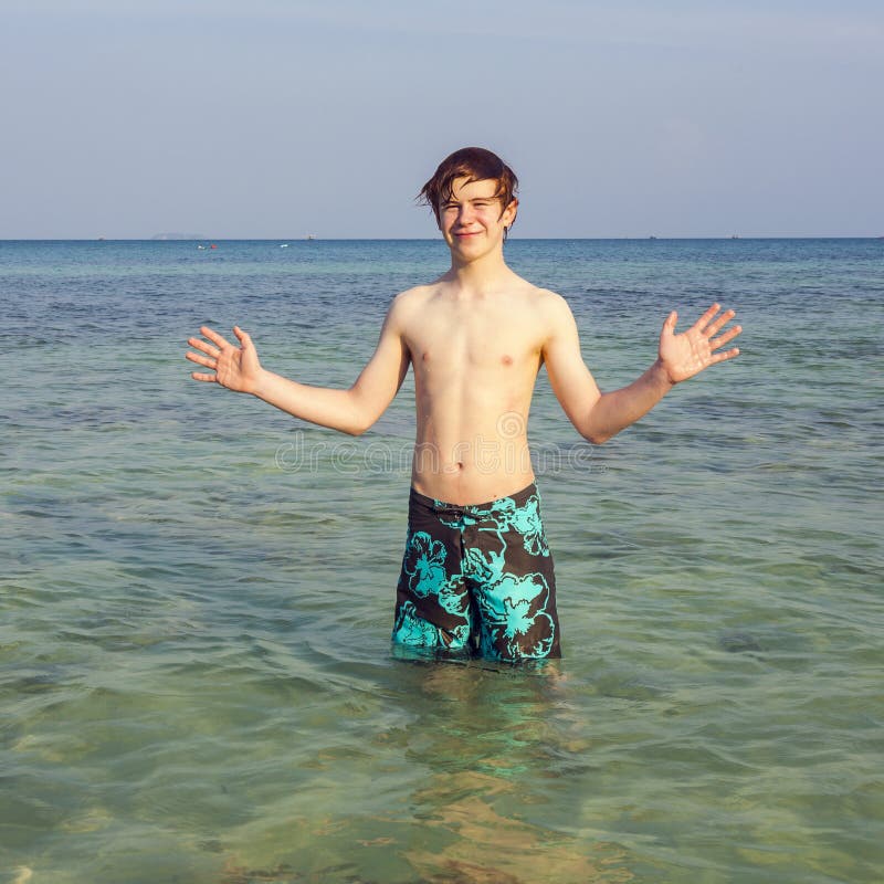 Teen boy is standing in the ocean