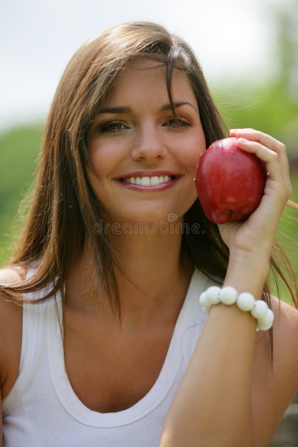 Teen eating red apple