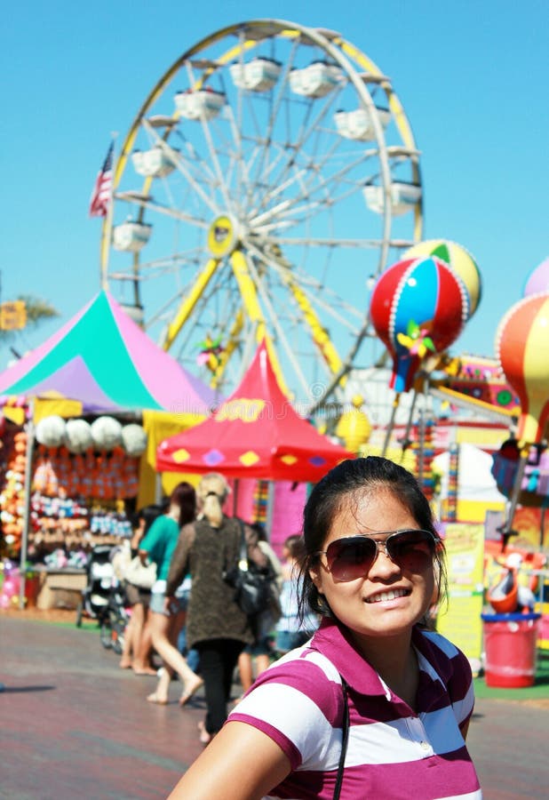 Happy young Filipina or Asian lady with ferris wheel ride and colorful festive background. Happy young Filipina or Asian lady with ferris wheel ride and colorful festive background.