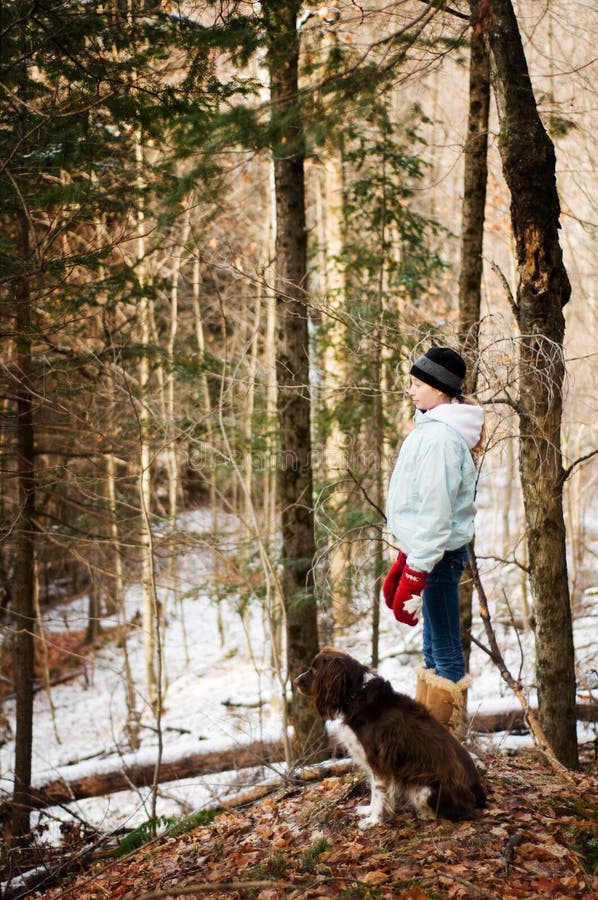 Teen girl in a forest with her dog