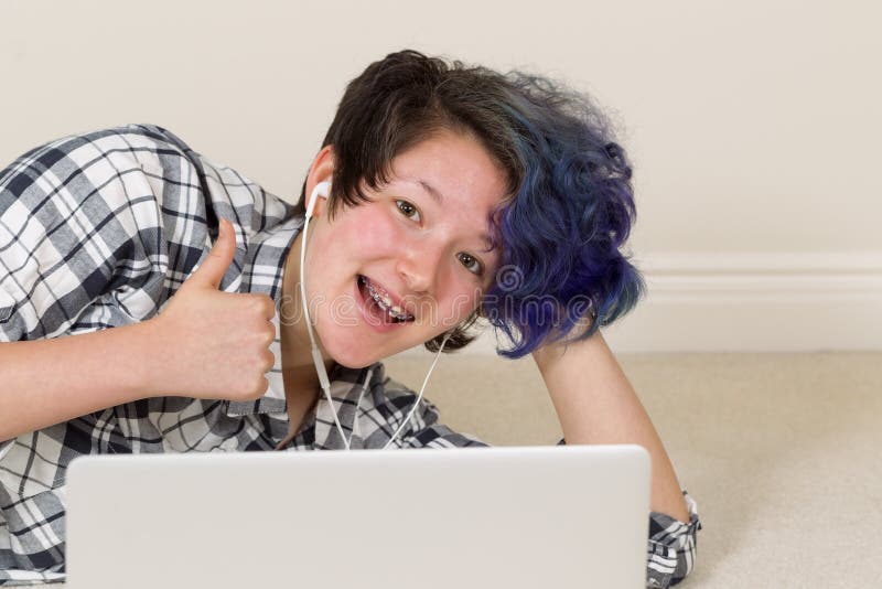 Teen Girl Giving Thumbs Up While At Home On Computer Stock -5296