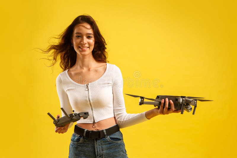 Teen Girl Launches Aerial Drone Quadcopter. Isolated on a Yellow ...