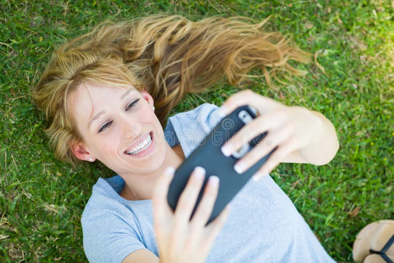 Teen Girl Laying In Grass Taking A Selfie With Her Smart Stock Image