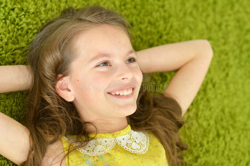 Teen girl lies on the carpet