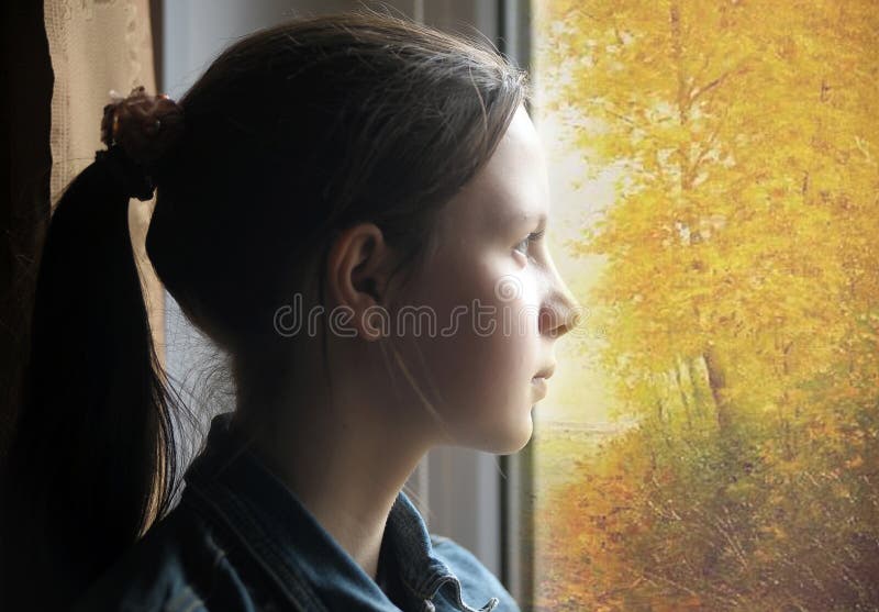 Teen girl looking out the window