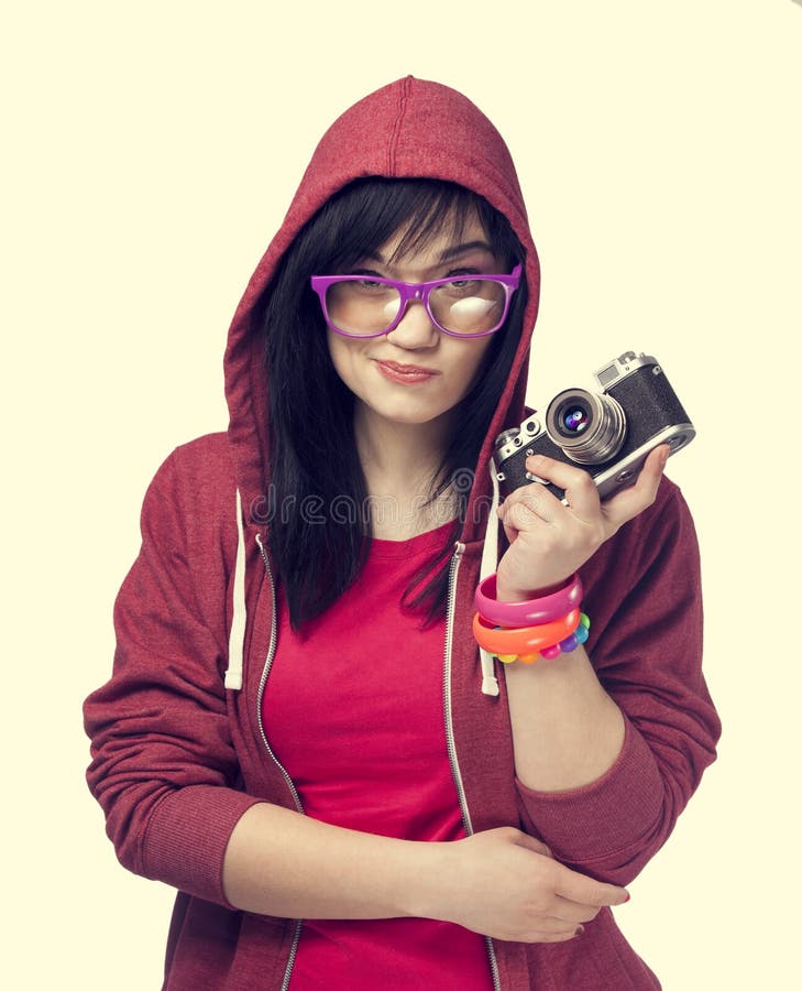 Teen girl in red with camera at white background.