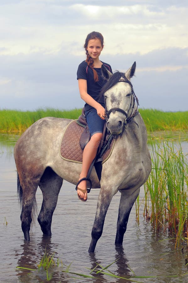 Teen girl riding a horse stock image