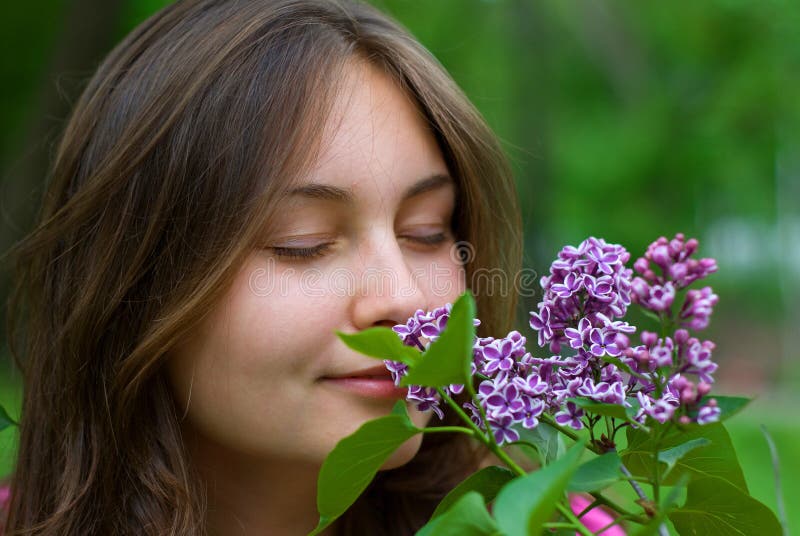 Teen girl sniffing lilacs