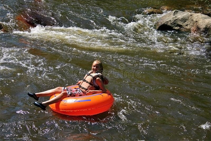 Teen Girl tubing down a river