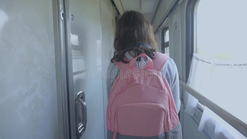 Teen girl walks on a train compartment car with lifestyle a backpack . travel transportation railroad concept.little