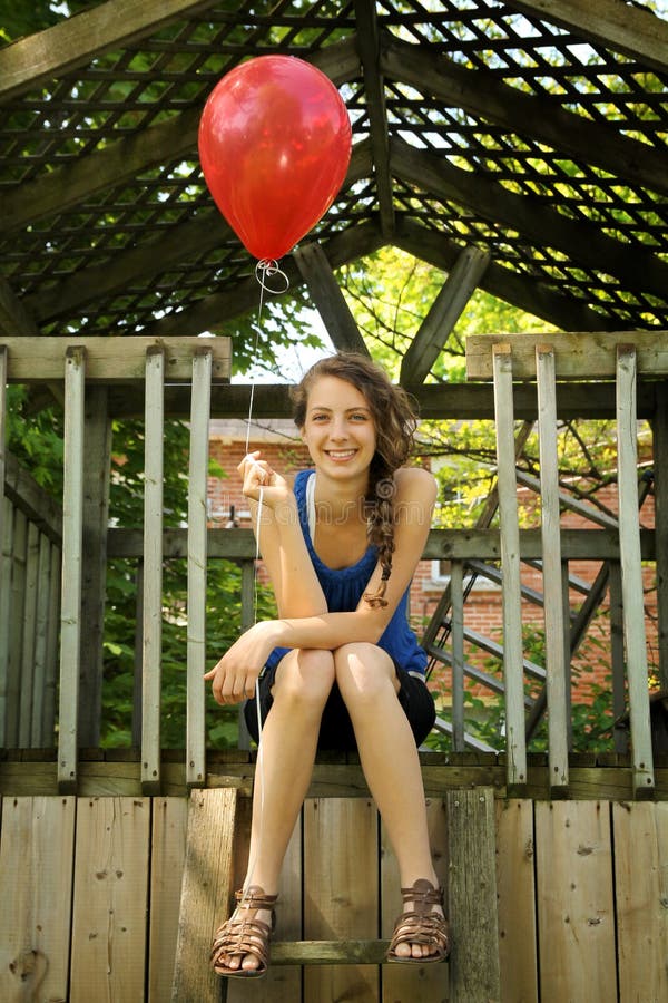 Teen holding a red balloon