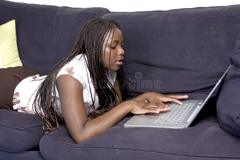 Teen laying down on couch with laptop