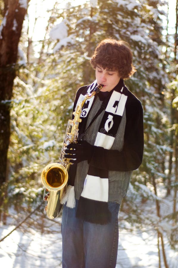 Teen playing saxophone in the snow