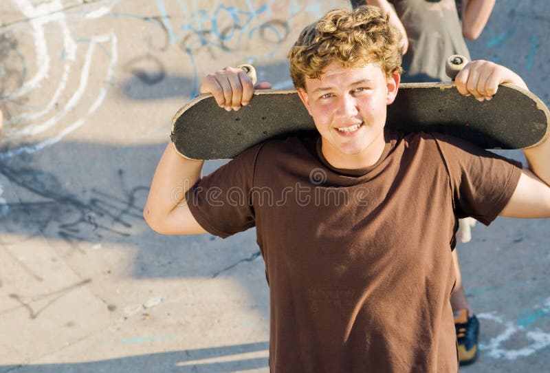 Young teen boy holding skateboard. Young teen boy holding skateboard