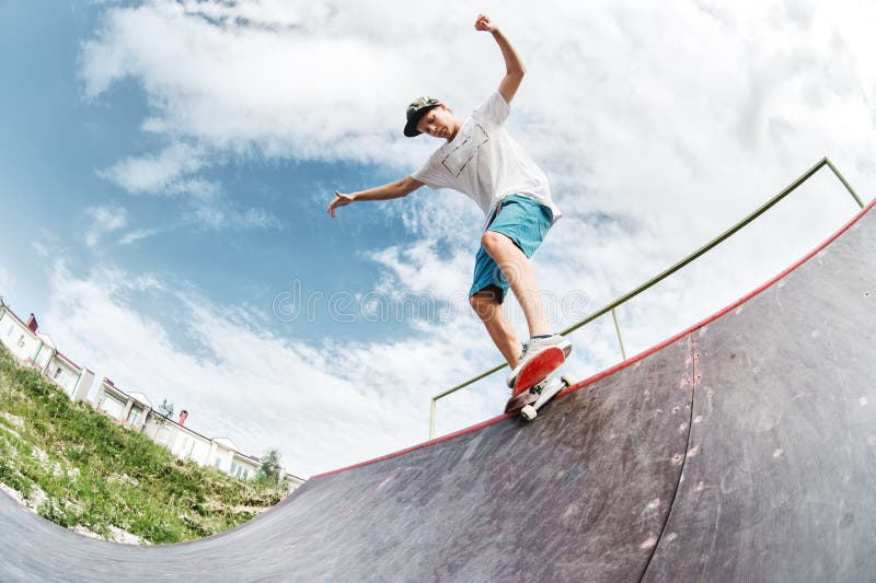 Teen Skater Hang Up Over a Ramp on a Skateboard in a Skate Park Stock ...