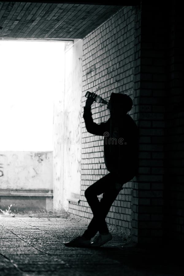 Teenader drinking beer and standing in the alley stock photos Teenader drinking beer and standing in the alley stock photos
