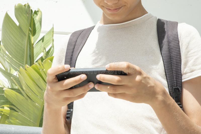 Teen boy distracting from online lesson and playing video games, scrolling  phone. Learning difficulties, online education, entertainment at home Stock  Photo - Alamy