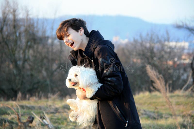 A teenage boy having fun with maltese dog royalty free stock photos A teenage boy having fun with maltese dog royalty free stock photos