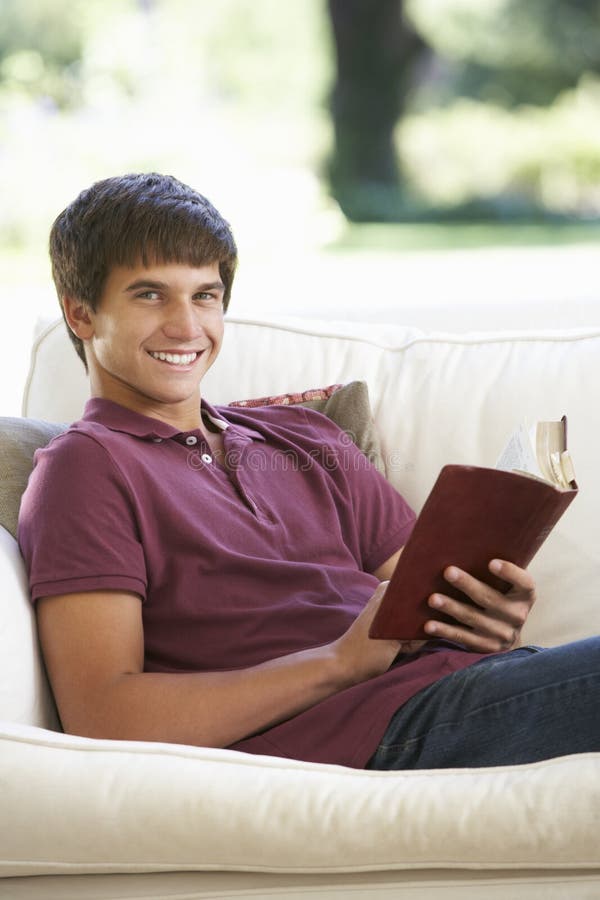 Подросток читает книгу дома. Молодой парень на диване фото домашнее. Что чаще всего читают подростки. Emotions Relaxed boy.