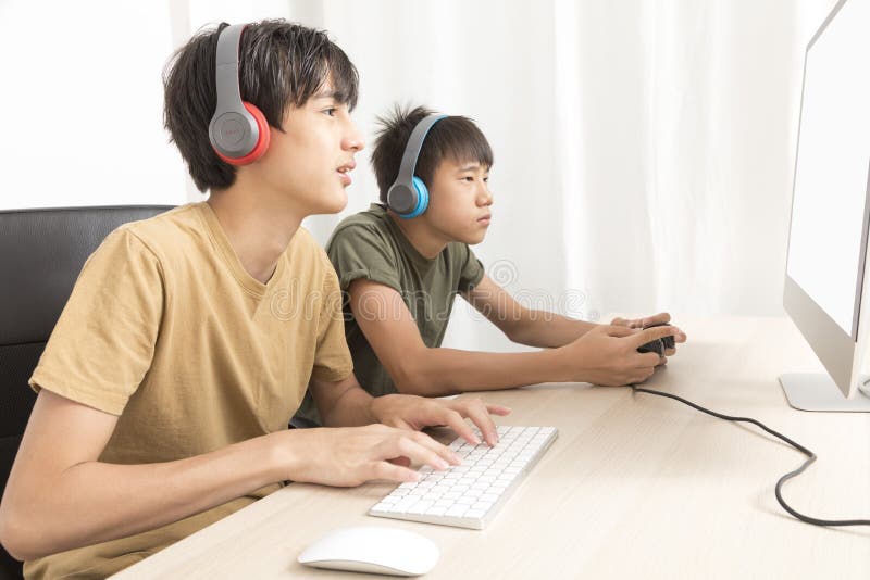 Teenage Couple With Headphone Play Game Online At Home Computer. Stock  Photo, Picture and Royalty Free Image. Image 172632258.