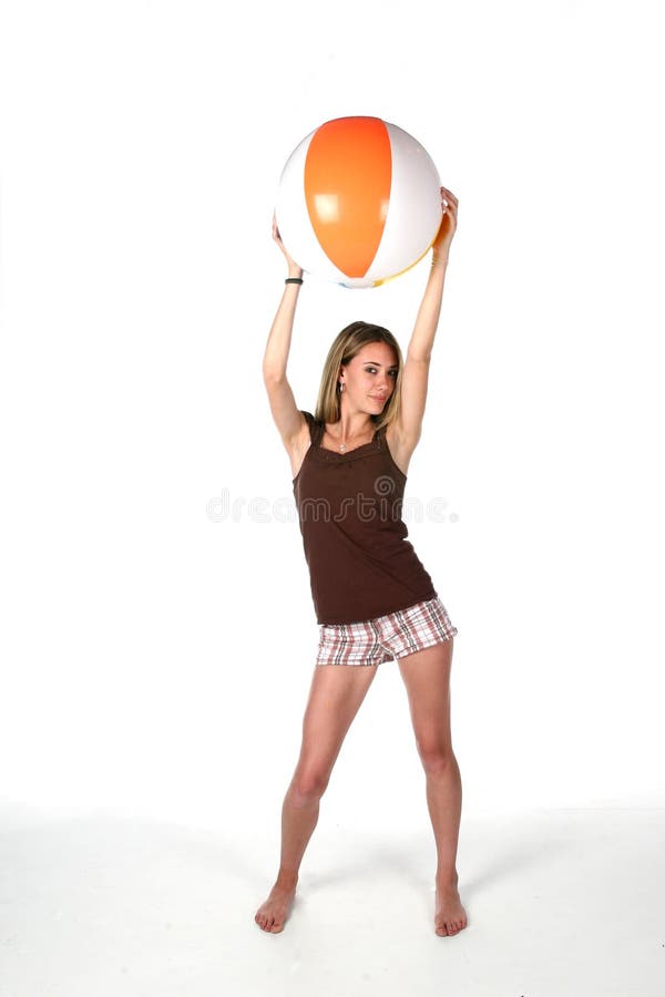 Teenage girl with beach ball up high