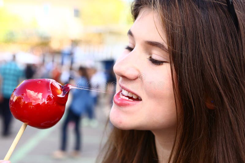 Teenage girl with candy red apple close up photo