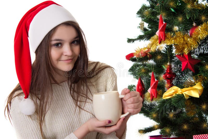 Teenage girl with coffee mug under Christmas tree