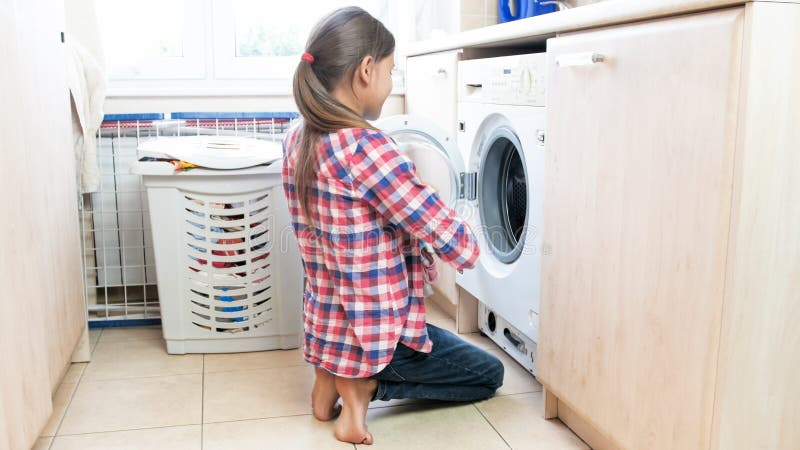 Young teenage girl doing housework in laundry room