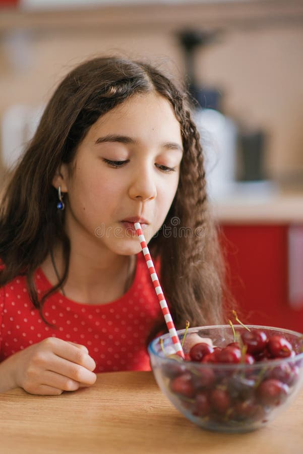 Teenage Girl Drinks Juice From A Cherry In A Plate Through A Straw The Concept Of An Organic