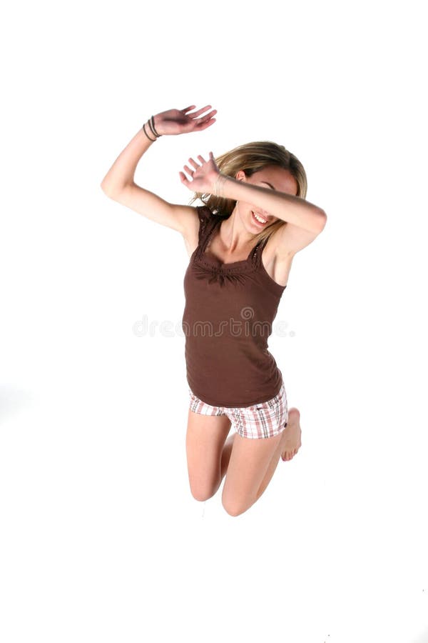 Teenage girl jumping with her arm over her eyes