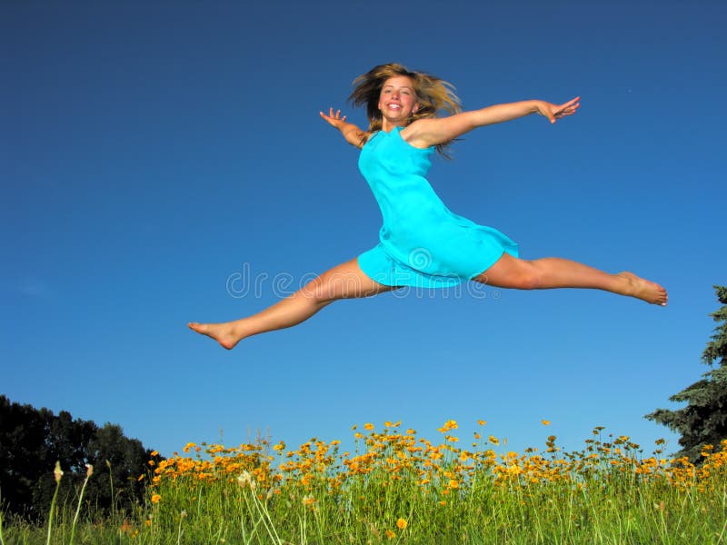 Teenage girl jumping in the meadow