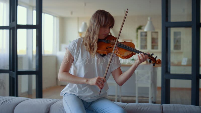 Teenage girl playing violin. Violinist playing chords on musical instrument