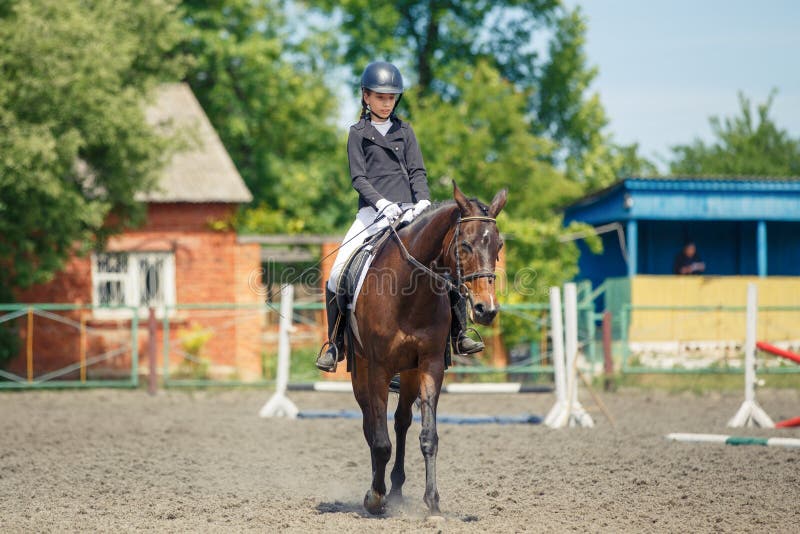 Teenage girl riding horse performing dressage test