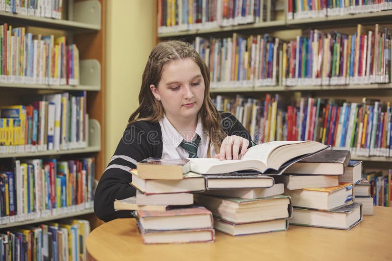 Teenage Girl with Converse High Tops Reading in Library Stock - Image hobby: 194085426