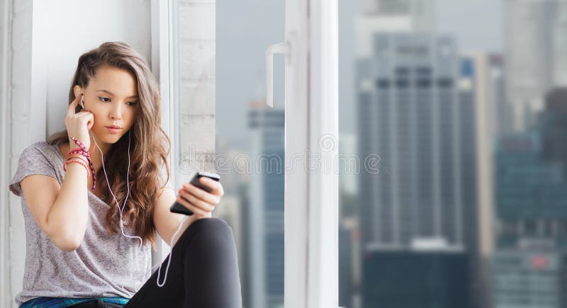 Teenage girl with smartphone and earphones