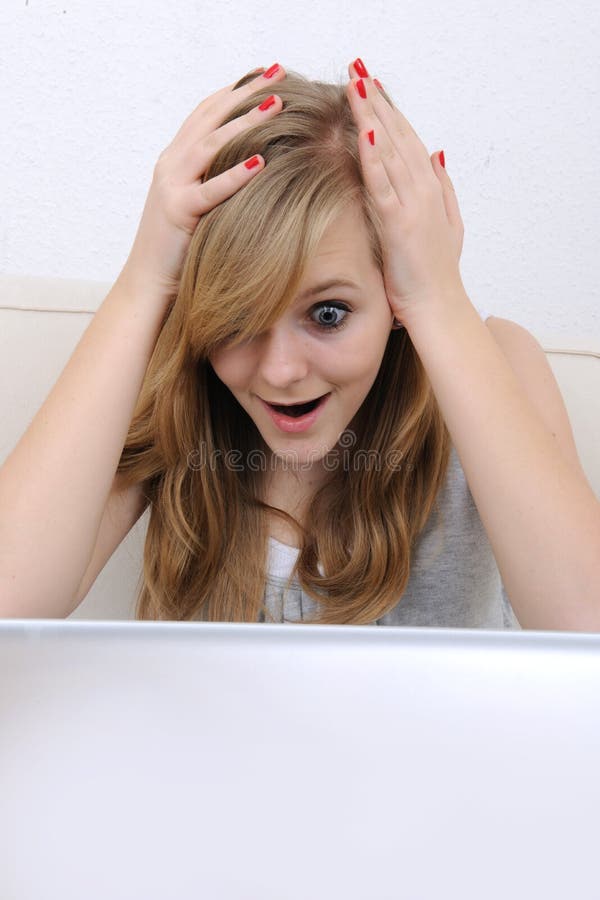 Teenage girl staring surprised at her laptop