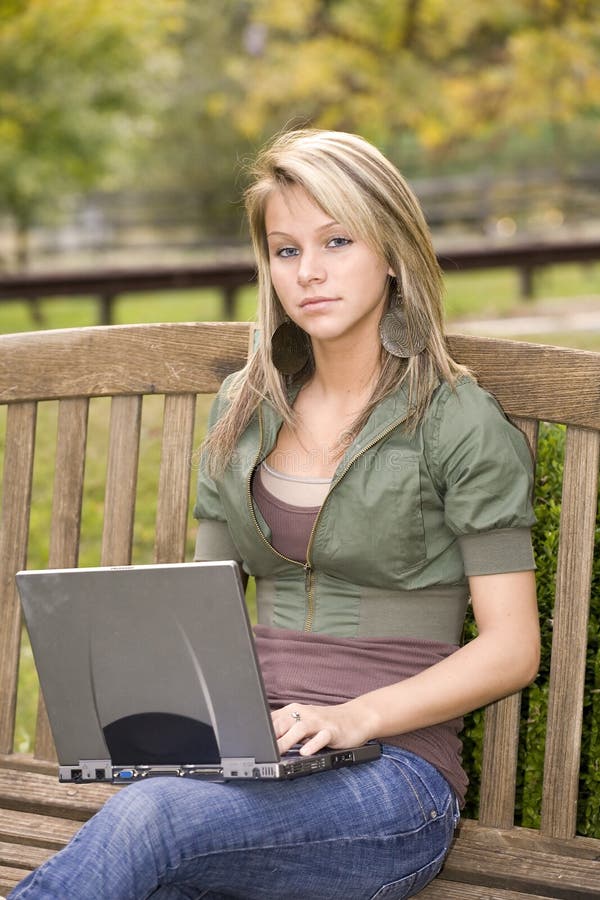 Teenage girl using her laptop in the park