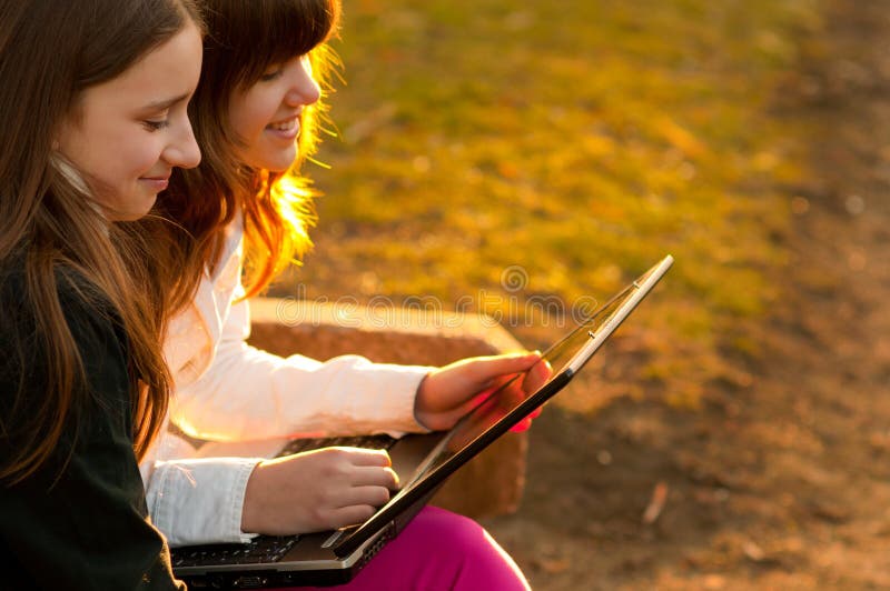 Teenage girls having fun with notebook