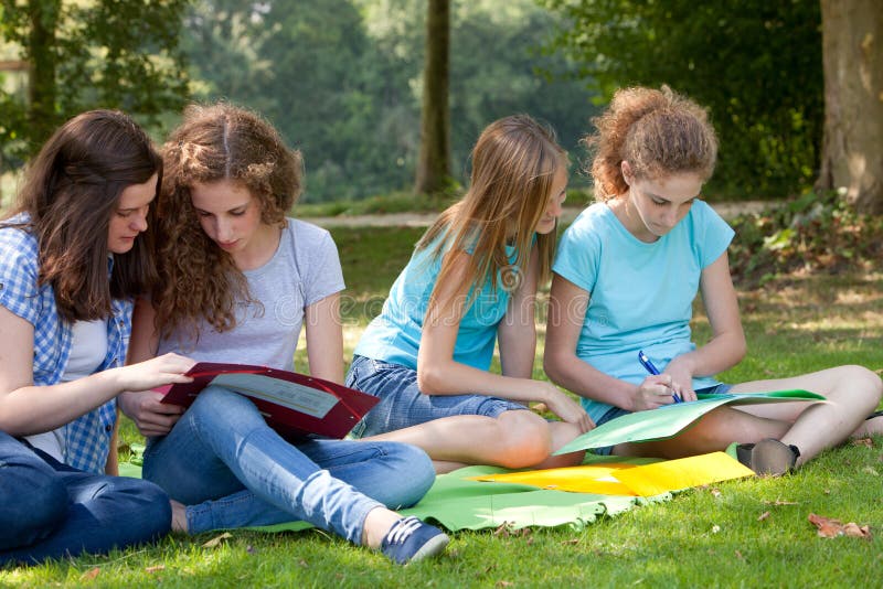 Teenage girls studying together in the park stock photography Teenage girls studying together in the park stock photography