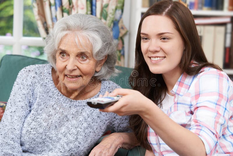 Teenage Granddaughter Watching Television With Grandmother stock photography Teenage Granddaughter Watching Television With Grandmother stock photography