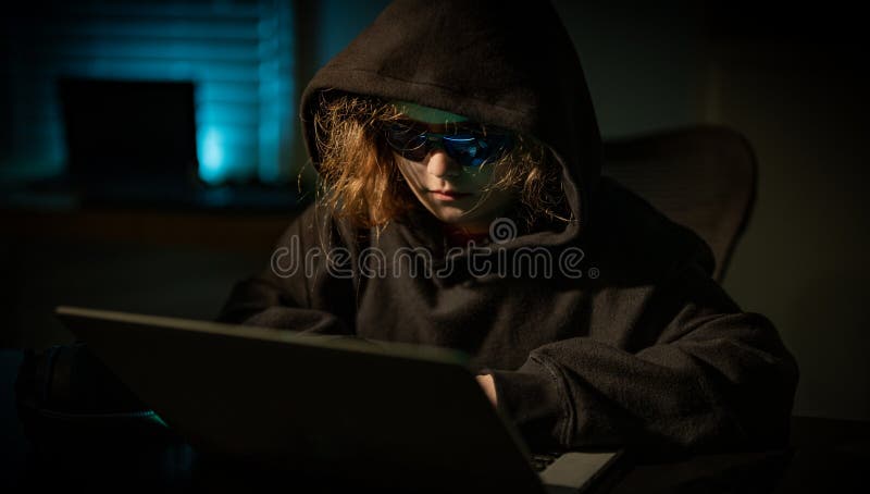 Teenage hacker working online in secret. Child hacker cyber security theme. Young hacker with anonymous digital identity. Kid stock image