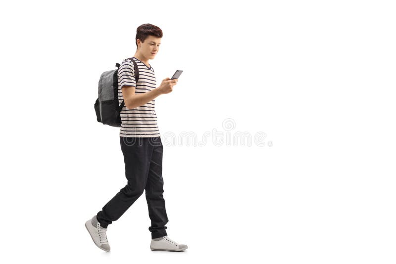 Teenage student walking and looking at a phone royalty free stock photography
